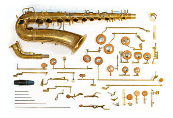 Altes Vintage Alto Saxophon in Einzelteile zerlegt auf weißem Hintergrund symbolisiert die Wichtigkeit der Bestandteile eines Teams, Musikstückes oder einer Produktion