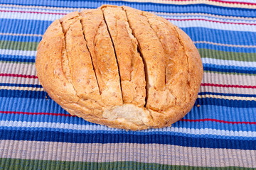 Sliced Round Loaf of Whole Grain Bread on a Colorful Placemat
