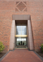 Modern entrance in brick, glass and brass office building