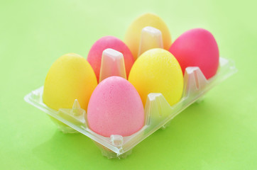 Fototapeta na wymiar Pink and yellow Easter eggs in a plastic holder