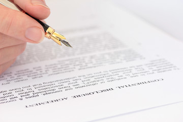Hand with Pen Checking Disclosure Agreement