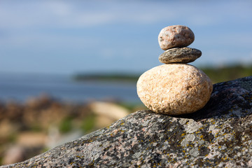 Fototapeta na wymiar Stones on the beach on blue sky background