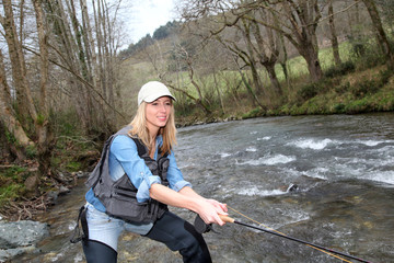 Woman fly-fishing in river