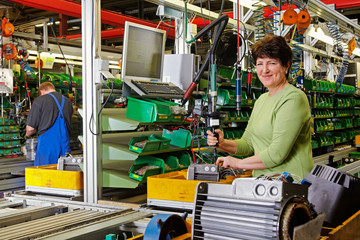 female skilled industrial worker, final assembly of electric mot