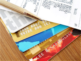 Pile of credit cards with pen and receipt.