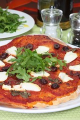 Pizza with ricotta cheese, olives and rocket salad