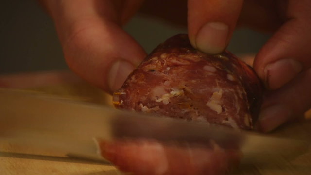 HD1080p25 Man carves slices of Sausage.