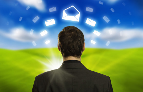 businessman with e-mail icons floating around his head