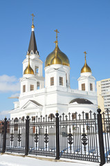 White church with golden domes and bell tower
