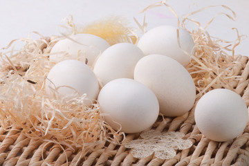 White eggs lying on straw base