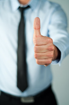 Young business man showing thumb up