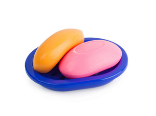 Soap of yellow and pinkcolor in a dark blue soap tray