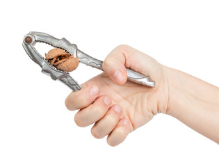 Woman hand cracking a walnut with metal nutcracker - 31057240