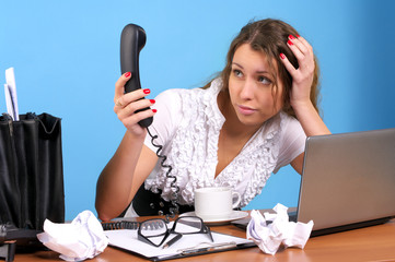 Beautiful businesswoman looking to telephone handset