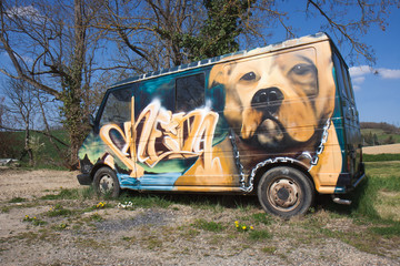 Graffiti d'un chien sur un vieux véhicule.