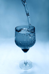 water is poured into a glass goblet forming bubbles