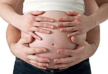 hands of pregnant woman and her husband on belly