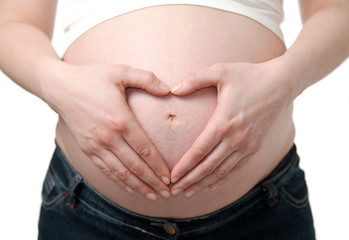 Pregnant woman with hands in the shape of a heart on her belly