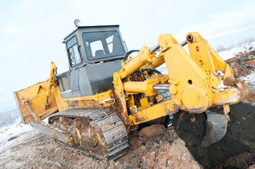 Obraz premium bulldozer loader at winter frozen soil excavation works