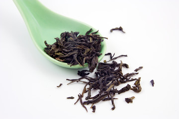 Green tea in green spoon isolated on a white background