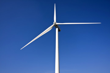 white wind turbine generating electricity on blue sky
