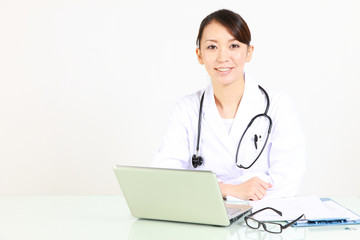 Fototapeta na wymiar japanese female doctor with laptop computer smiles