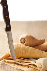 Parsley root and knife on a rustic table