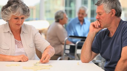 Elderly couple playing dominos - Powered by Adobe