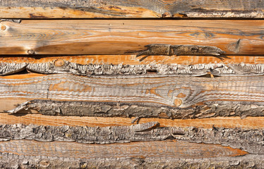 Wooden wall with boards with bark