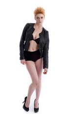 Pretty young female in heels and jacket isolated