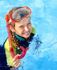 Child in swimming pool learning snorkeling.