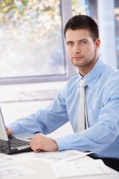 Young businessman sitting in bright office
