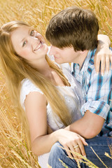 young couple sitting in grain field