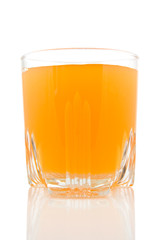 glass of juice on white background with reflection