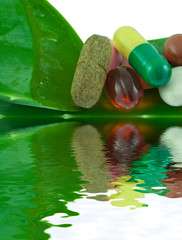 gélules comprimés et capsules sur feuille d'aloe vera vert