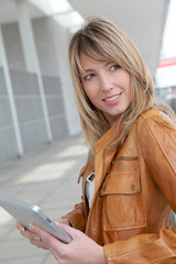 Beautiful woman using electronic tablet in town