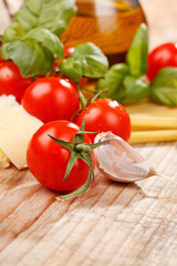 pasta, olive oil and tomatoes on the wood background