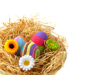 Colorful Easter eggs on hay in the basket