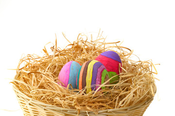 Colorful Easter eggs on hay in the basket