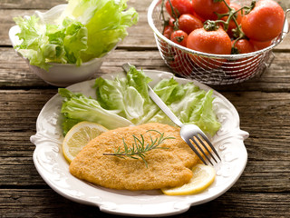 cutlet breaded with salad on dish