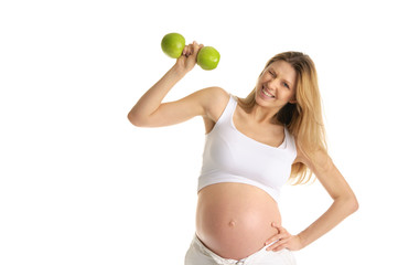 pregnant woman is engaged in fitness dumbbells from apples