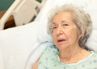 Elderly 80 year old woman with Alzheimer in a hospital bed
