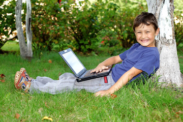 boy with notebook sit at tree outdoors