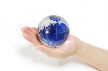 ガラスの地球儀を持つ女性の手