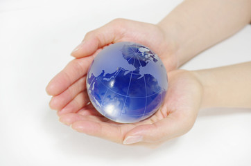 ガラスの地球儀とを持つ女性の手