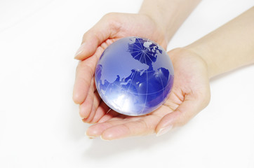 ガラスの地球儀を持つ女性の手