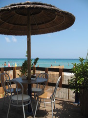 Coffee table of the beach pub, with wicker umbrella