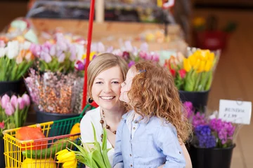 Crédence de cuisine en verre imprimé Fleuriste petite fille embrasse sa mère en achetant des fleurs