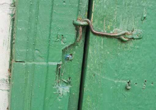 Rusty hook on a dirty green door