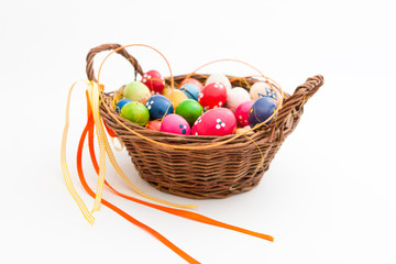 Geflochtener Korb gefüllt mit vielen bunten Eiern für Ostern